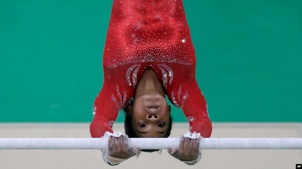 Gabrielle Douglas entrena en las barras paralelas durante la competencia de gimnasia femenina, que fue dominada por Estados Unidos.