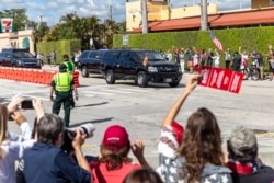 Para pendukung melambaikan tangan ke iring-iringan mobil Presiden Trump yang menuju Mar-a-Lago.