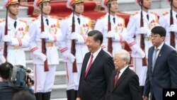 资料图片：2017年11月12日，中国国家主席(中)和越共总书记阮富仲在越南河内总统府举行的欢迎仪式上。
