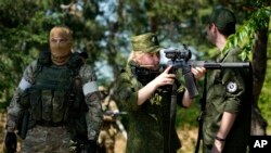 资料照：乌克兰东部夏斯季亚镇附近一名俄军女兵用狙击步枪瞄准。（2022年6月11日）