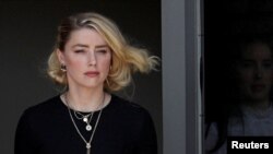 Amber Heard berjalan meninggalkan gedung pengadilan Fairfax County setelah juri mengumumkan putusan yang menguntungkan mantan suaminya Johnny Depp dalam kasus pencemaran nama baik yang membelit mereka berdua, di Virginia,  AS, pada 1 Juni 2022. (Foto: Reuters/Tom Brenner)
