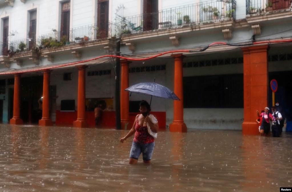 Ein Frau überquert eien überflutete Straße in Havanna. | Bildquelle: VOA | Bilder sind in der Regel urheberrechtlich geschützt