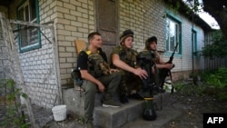 Ukrainian servicemen rest on their position not far from the Ukrainian town of Chuguiv, in Kharkiv region on June 9, 2022.