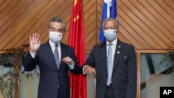 FILE - In this photo released by Xinhua News Agency, Secretary-General Pacific Islands Forum Secretariat Henry Puna, right, and visiting Chinese Foreign Minister Wang Yi pose for a photo before their meeting in Suva, Fiji, Sunday, May 29, 2022.