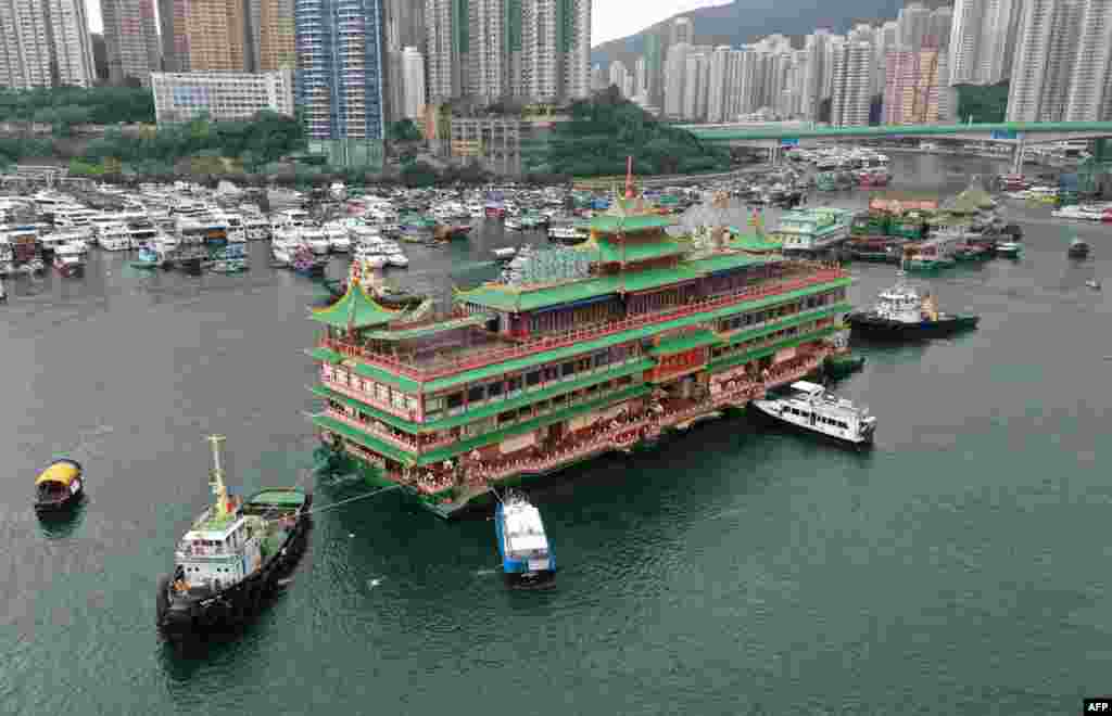 Hong Kong&#39;s Jumbo Floating Restaurant, an famous but aging tourist attraction designed like a Chinese imperial palace, being towed out of Aberdeen Harbor, after its popularity dimmed in recent years even before the coronavirus hit.&nbsp;(Photo by Peter PARKS / AFP)