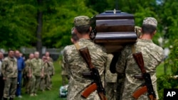 Ukrainian servicemen carry the coffin with the remains of Army Col. Oleksander Makhachek during his funeral in Zhytomyr, Ukraine, June 3, 2022.