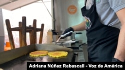 Un hombre prepara una cachapa en Bogotá, Colombia.