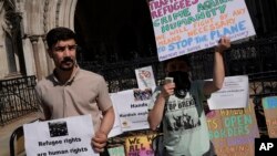 برخی از معترضان به حکم اخراج پناهجویان به رواندا در بیرون محکمۀ عالی بریتانیا در شهر لندن تجمع کردند.