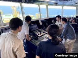 Membros da tripulação a bordo do petroleiro autônomo Prism Courage monitoram o progresso durante uma viagem de um porto no Texas para a Coreia do Sul.  (Crédito da imagem: Avikus/SK Versand)