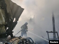 A firefighter extinguishes a fire at a warehouse following recent shelling during the Ukraine-Russia conflict in Donetsk, Ukraine, June 6, 2022.