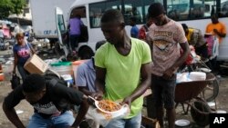 Un hombre vende comida caliente en un mercado en Puerto Príncipe, Haití. [Foto de archivo]