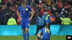 Ukraine's Vitaliy Mykolenko, left, and Ukraine's Mykhailo Mudryk are seen in dejection at the end of the World Cup 2022 qualifying play-off soccer match between Wales and Ukraine at Cardiff City Stadium, in Cardiff, Wales, June 5, 2022. Wales won 1-0.