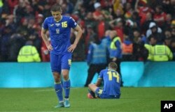 Ukraine's Vitaliy Mykolenko, left, and Ukraine's Mykhailo Mudryk are seen in dejection at the end of the World Cup 2022 qualifying play-off soccer match between Wales and Ukraine at Cardiff City Stadium, in Cardiff, Wales, June 5, 2022. Wales won 1-0.