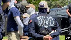 Authorities arrest members of the white supremacist group Patriot Front near an Idaho pride event, June 11, 2022, after they were found packed into the back of a U-Haul truck with riot gear.