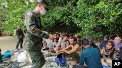 (မွတ္တမ္း ပုံေဟာင္း) In this photo released by the Royal Thai Navy taken June 4, 2022, members of the Thai navy help Rohingya refugees found on Koh Dong Island in Satun province, southern Thailand.