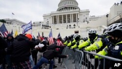 FILE - Violent insurrections loyal to President Donald Trump break through a police barrier at the Capitol in Washington. 