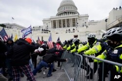 FILE - Violent protestors loyal to former President Donald Trump break through a police barrier at the Capitol in Washington, D.C. on Jan. 6, 2021. (AP Photo/Julio Cortez, File)