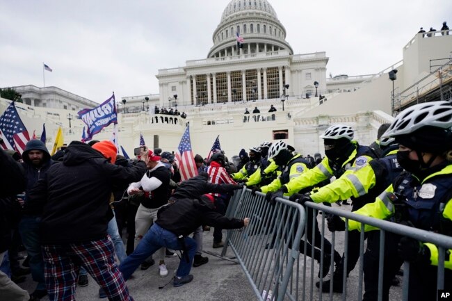 FILE - Violent protestors loyal to former President Donald Trump break through a police barrier at the Capitol in Washington, D.C. on Jan. 6, 2021. (AP Photo/Julio Cortez, File)