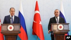 Russian Foreign Minister Sergey Lavrov, left, and Turkish Foreign Minister Mevlut Cavusoglu talk to journalists during a joint news conference in Ankara, Turkey, June 8, 2022. 