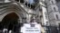 Protesters stand outside The Royal Court of Justice in London that will hear a legal challenge opposing the Home Office's new asylum deal with Rwanda, June 10, 2022.