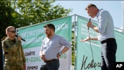 FILE - In this June 7, 2015, file photo, Russian opposition activist and blogger Alexey Navalny, right, argues with a man in a military uniform, left, as opposition activist Leonid Volkov, center, listens during a rally in Novosibirsk, Siberia's biggest city, Russia.