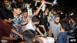 Rescue workers and civilians carry an injured person to a hospital after a fire broke out at a container storage facility in Chittagong, Bangladesh, on June 5, 2022. 