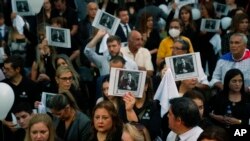 Personas sosteniendo una imagen del difunto fiscal antidrogas Marcelo Pecci asisten a una reunión para exigir justicia por su asesinato, en Asunción, Paraguay, el 13 de mayo de 2022.