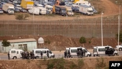 Paramilitaries of the Moroccan Auxiliary Forces stand guard by the border fence separating Morocco from Spain's North African Melilla enclave after an attempted assault of migrants near Nador, March 4, 2022. 