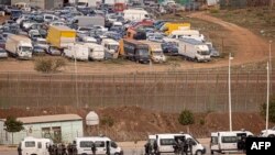 FILE - Paramilitaries of the Moroccan Auxiliary Forces stand guard by the border fence separating Morocco from Spain's North African Melilla enclave after an attempted assault of migrants near Nador, March 4, 2022. 