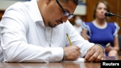 Miguel Cerrillo, the father of Miah Cerrillo, who survived the May 24 school shooting in Uvalde, Texas, takes notes as victims’ parents and survivors of Uvalde and Buffalo shootings testify before a House Oversight Committee hearing on gun violence in Washington, June 8, 2022.