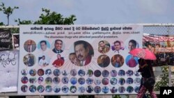 Sri Lankans walk past anti-government propaganda displayed at the on going protest site near president's office in Colombo, Sri Lanka, June 5, 2022. 