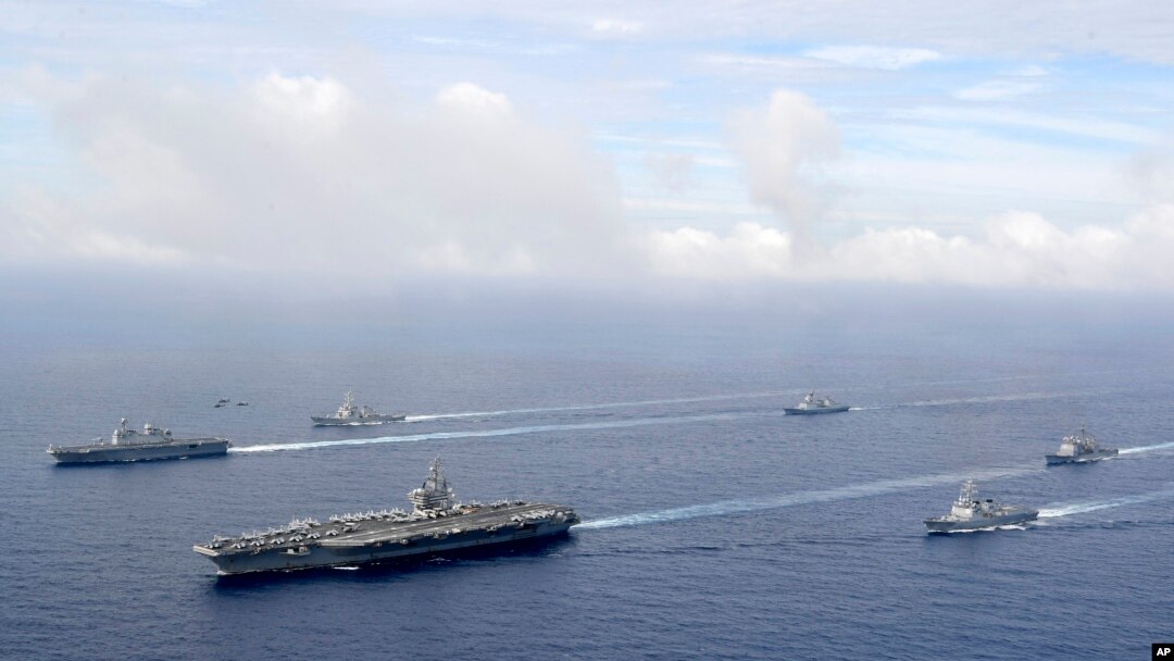 Kapal induk militer AS USS Ronald Reagan (kedua dari kiri) dan kapal militer Korea Selatan Marado (kiri) berlayar dalam latihan militer gabungan kedua negara di lokasi yang tidak diketahui pada 4 Juni 2022. (Foto: South Korea Defense Ministry via AP)