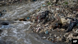 Plastic bottles and waste float pollute the Las Vacas river in Chinautla, near Guatemala City, Wednesday, June 8, 2022.