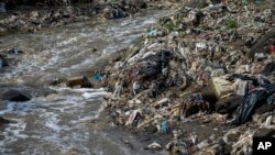 Plastic bottles and waste float pollute the Las Vacas river in Chinautla, near Guatemala City, Wednesday, June 8, 2022.