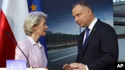 Polish President Andrzej Duda (right) and European Commission President Ursula von der Leyen speak after at a joint news conference with Poland's Prime Minister Mateusz Morawiecki at the headquarters of Poland's Power Grid in Konstancin-Jeziorna, Poland, 