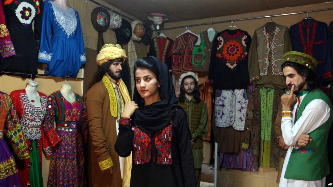 
In this Aug. 3, 2017 photo, a model, center, wearing traditional Afghan clothing practices modeling, in Kabul, Afghanistan. Her employer was Ajmal Haqiqi.