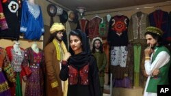 
In this Aug. 3, 2017 photo, a model, center, wearing traditional Afghan clothing practices modeling, in Kabul, Afghanistan. Her employer was Ajmal Haqiqi.