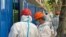 Workers in protective suits set up barriers outside a building, following the coronavirus disease (COVID-19) outbreak, in Shanghai, China, June 9, 2022. 