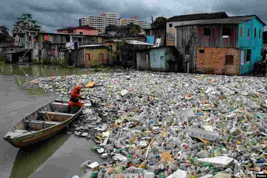 Seorang pekerja kota membersihkan sampah yang terbawa aliran sungai Sao Jorge, menyusul hujan lebat di Manaus, negara bagian Amazonas, Brazil. (Foto: Reuters)