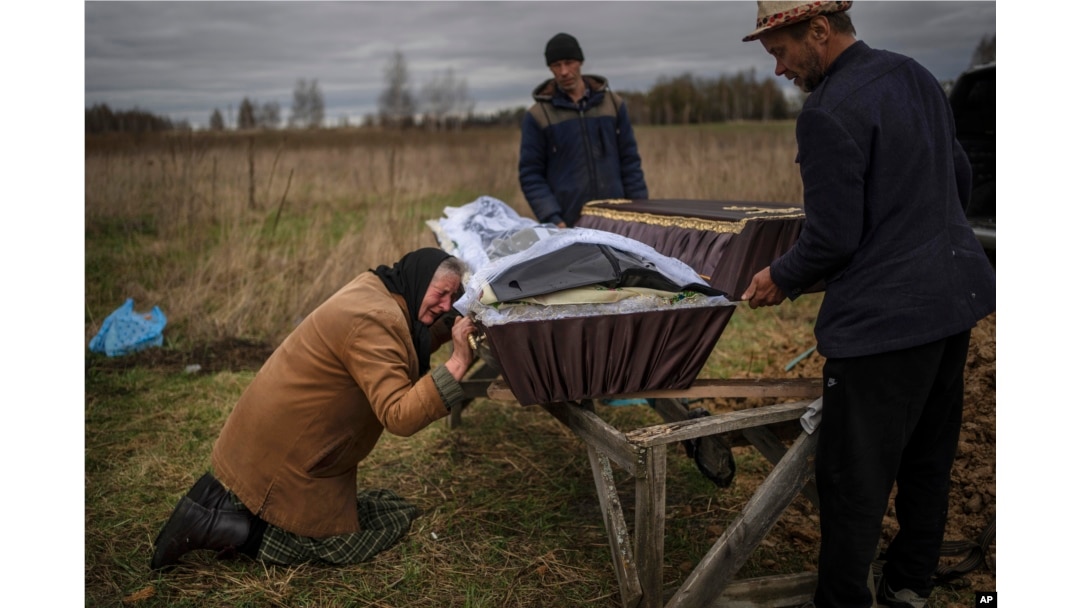 FILE - Nadiya Trubchaninova cries over the coffin of her son, Vadym, who was killed on March 30 by Russian soldiers in Bucha, Ukraine, during his funeral in the cemetery of nearby Mykulychi, on the outskirts of Kyiv, on April 16, 2022.