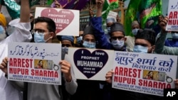 Indian Muslims hold signs demanding the arrest of Hindu nationalist party, BJP, over comments about Islam and the Prophet Muhammad, June 6, 2022. At least five Arab nations have also entered official protests against India. (AP Photo/Rafiq Maqbool)