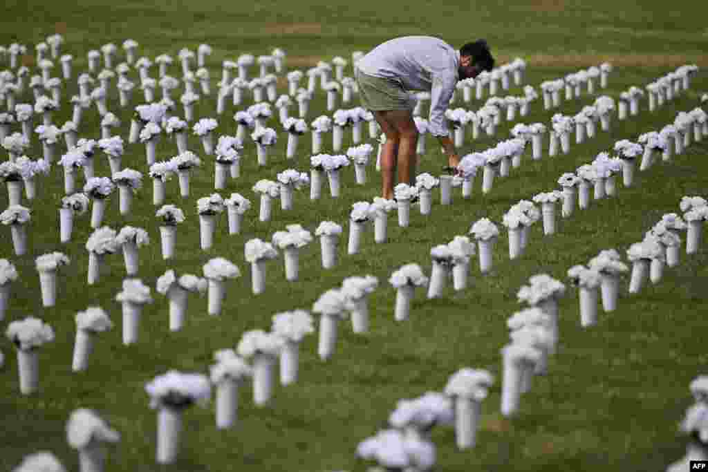 A person adjusts flowers ahead of the opening of the Gun Violence Memorial on the National Mall in Washington, DC, June 7, 2022.