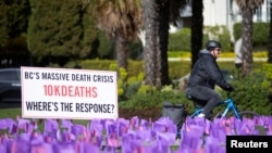 Seorang pengendara sepeda melewati ratusan bendera yang melambangkan lebih dari 10.000 orang yang telah meninggal karena overdosis obat beracun di British Columbia, Kanada, 14 April , 2022. (REUTERS/Jesse Winter/File Foto)