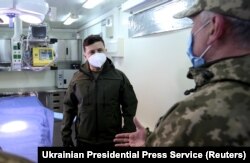 Presiden Ukraina Volodymyr Zelenskyy mengenakan masker memeriksa laboratorium berjalan milik militer. (Foto: via Reuters)