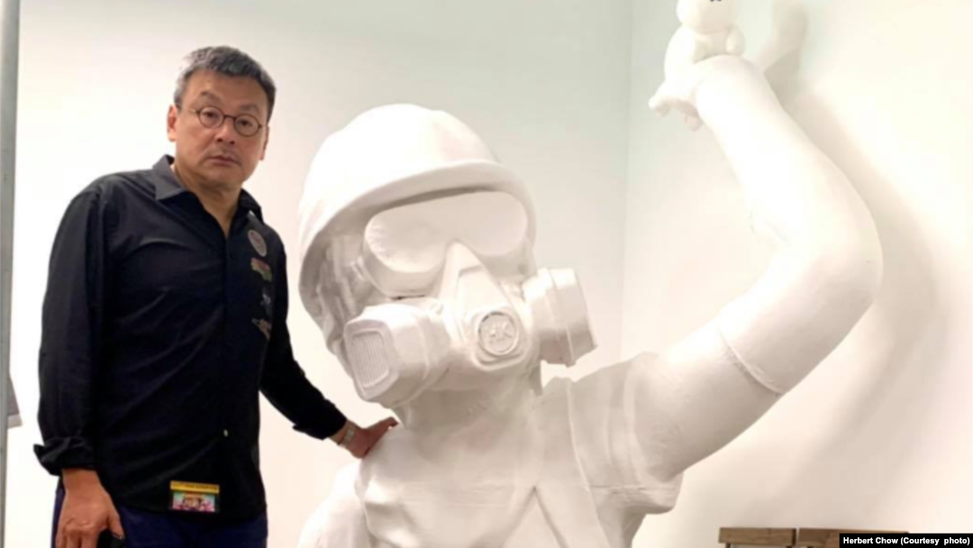 周小龍與巨型雕像合照。(圖片來源:周小龍臉書網站)