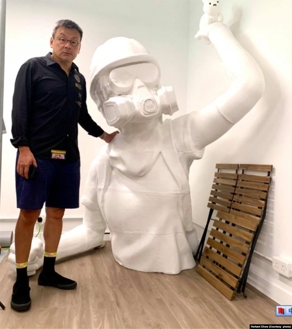 周小龙与巨型雕像合照 (图片来源：周小龙脸书网站)(photo:VOA)
