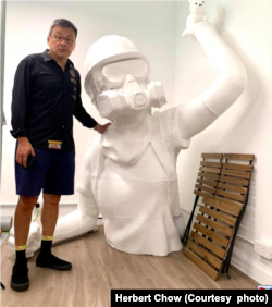 周小龙与巨型雕像合照 (图片来源：周小龙脸书网站)