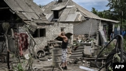 Maksym Katerin en el patio de su casa dañada después de que su madre y su padrastro murieran durante un bombardeo en la ciudad de Lysychansk, en la región oriental de Ucrania de Donbas, el 13 de junio de 2022, en medio de la invasión rusa de Ucrania.