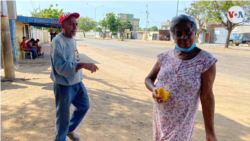Carmen Castillo, de 80 años, posa mientras come uno de los múltiples mangos que caen a diario en su patio, en el sector Altos de Milagro Norte, en Venezuela. [Foto: Gustavo Ocando Alexa, VOA]
