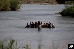 FILE - Migrants, mostly from Nicaragua, cross the Rio Grande River into the U.S., at Eagle Pass, Texas, May 20, 2022.